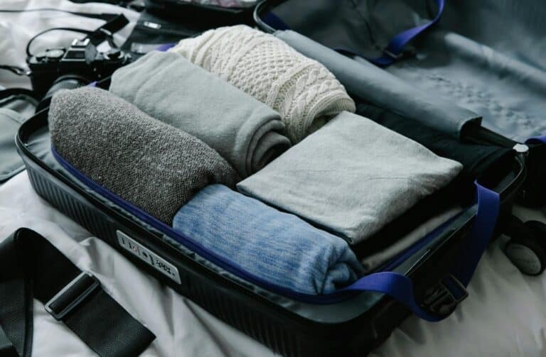 Suitcase with clothes on a bed